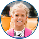 Portfolio photo of a young girl in front of a school bus